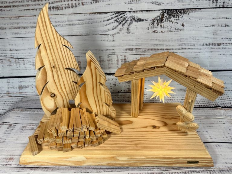 Oberlausitzer Sternel Hütte Oberlausitzer Sternel Hütte mit originalem Herrnhuter Mini Stern aus Lärchenhollz mit zwei Bäumen und einem Holzhaufen - Ansicht von vorn